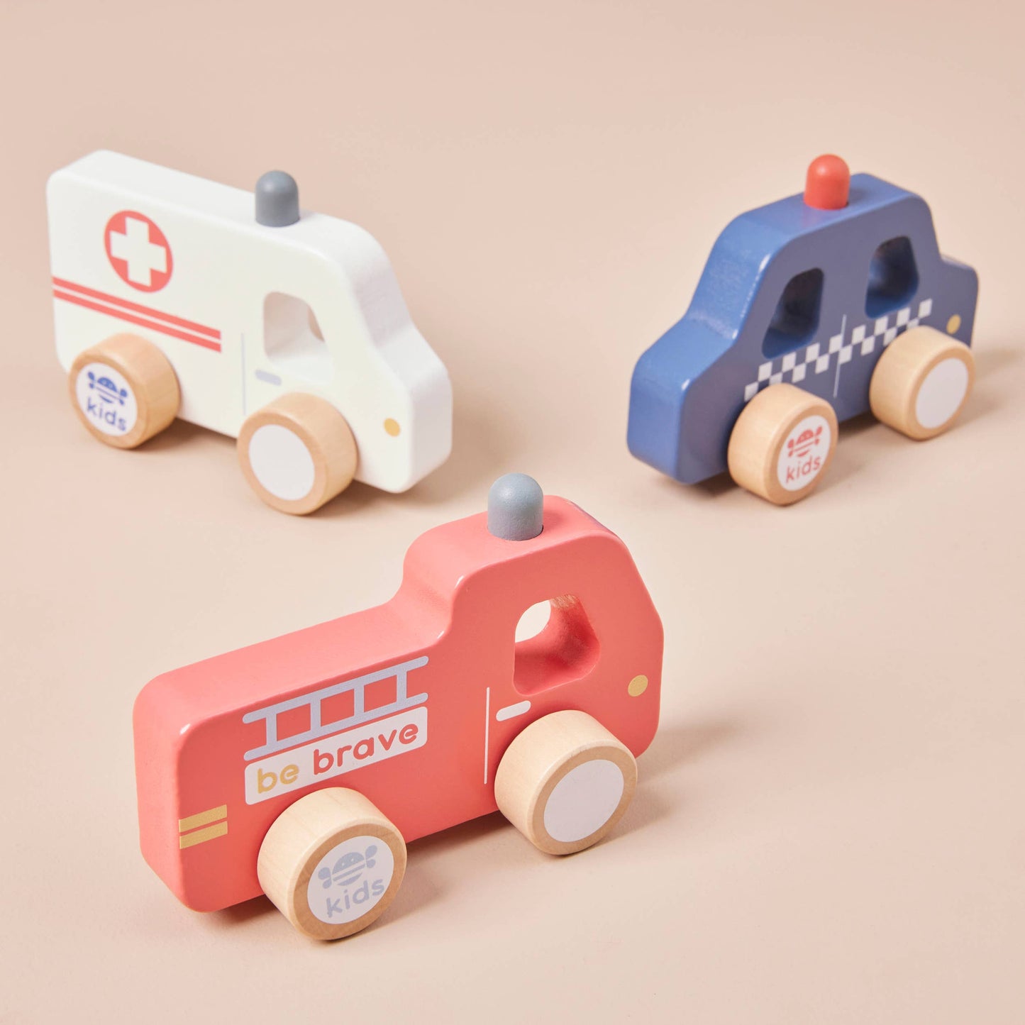 Three wooden toy vehicles on a beige background