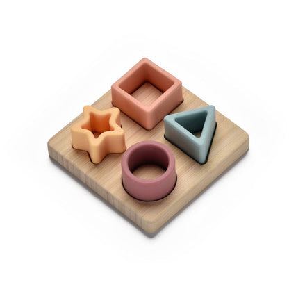 Set of colourful silicone shape sorting toys on a wooden base with white background