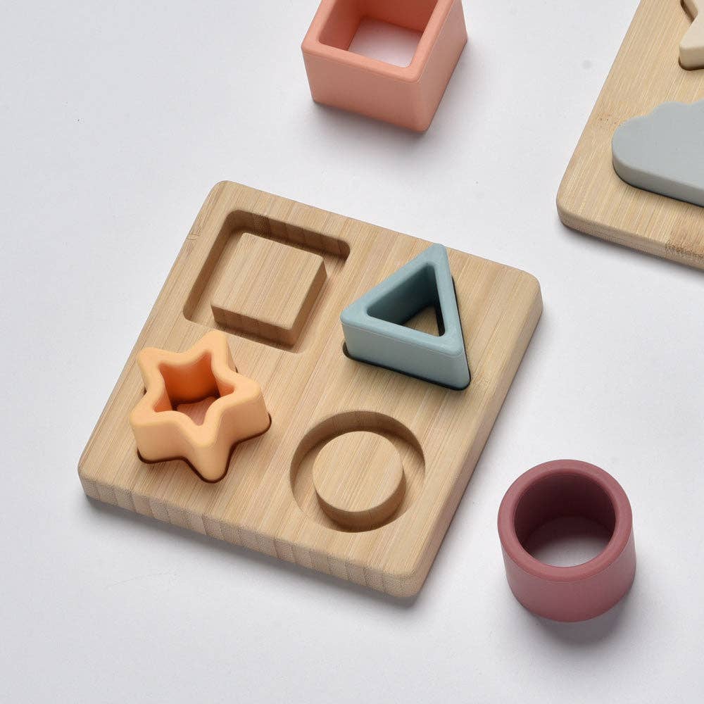 Wooden shape sorting toy with colourful geometric shapes on a light grey background