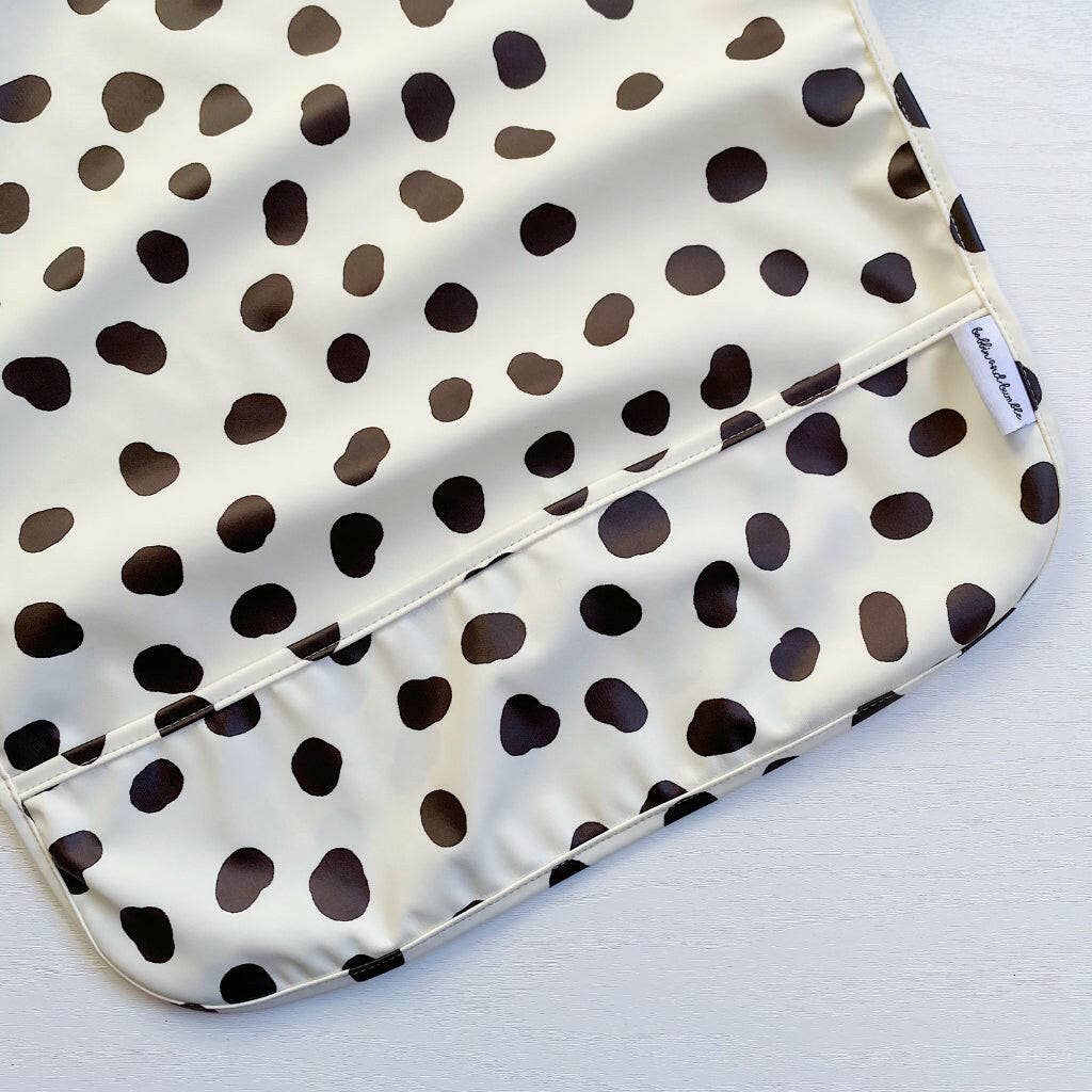 Polka dot patterned bib with a visible brand label on a white background