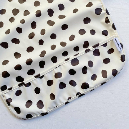 Polka dot patterned bib with a visible brand label on a white background