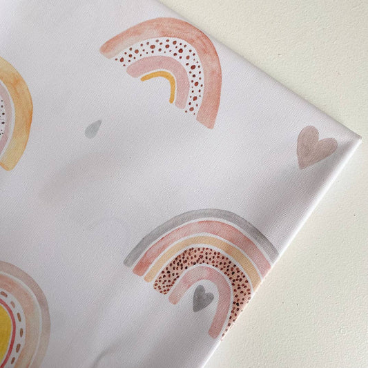 Splashmat with rainbow and heart designs on a light background