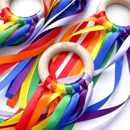 Wooden rings with colorful ribbons on a white background