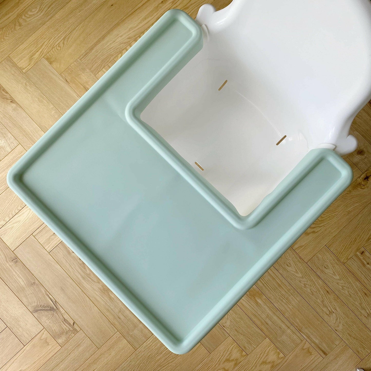 Light green silicone mat on white Ikea highchair