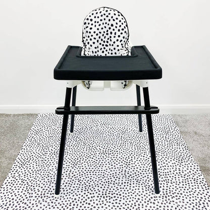 Black high chair with a white cushion with black dots on a white background