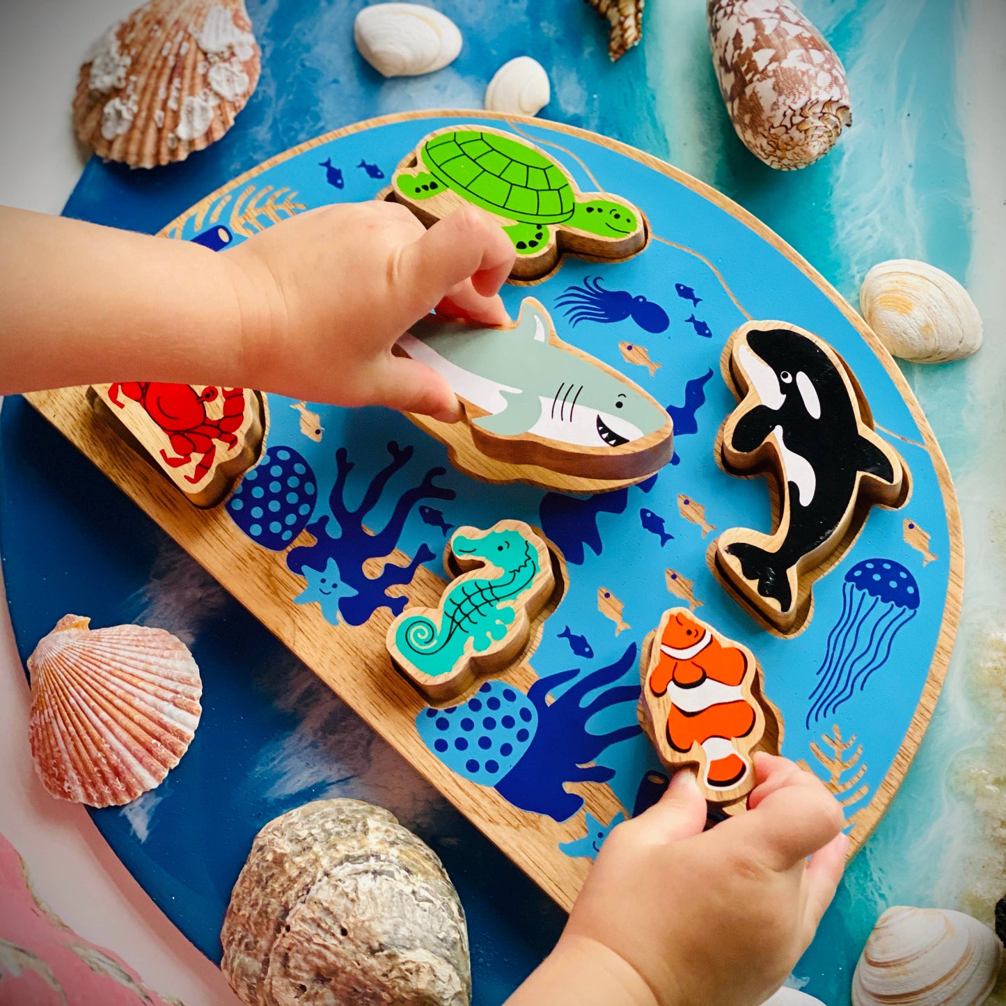 Children's play mat with ocean-themed wooden puzzle and sea shells
