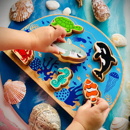 Children's play mat with ocean-themed wooden puzzle and sea shells