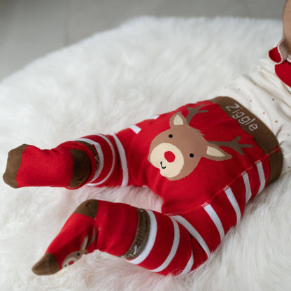 Red and white striped baby romper with a reindeer design on a white blanket