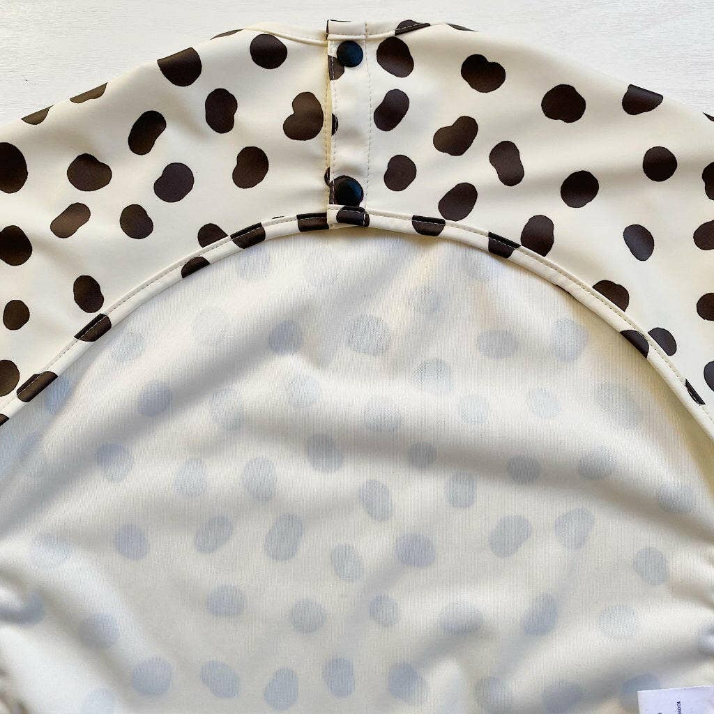Close-up of the back of a polka dot bib with a white background
