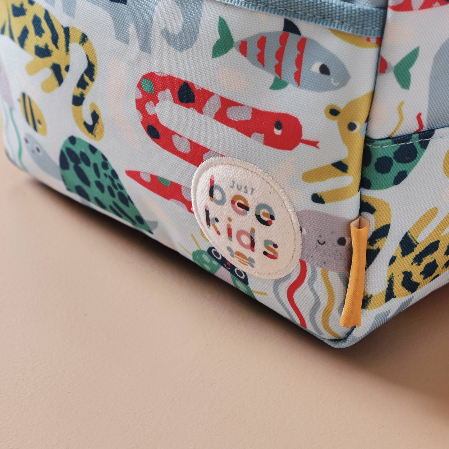 Children's pouch with animal pattern and 'bee kids' label on a beige background