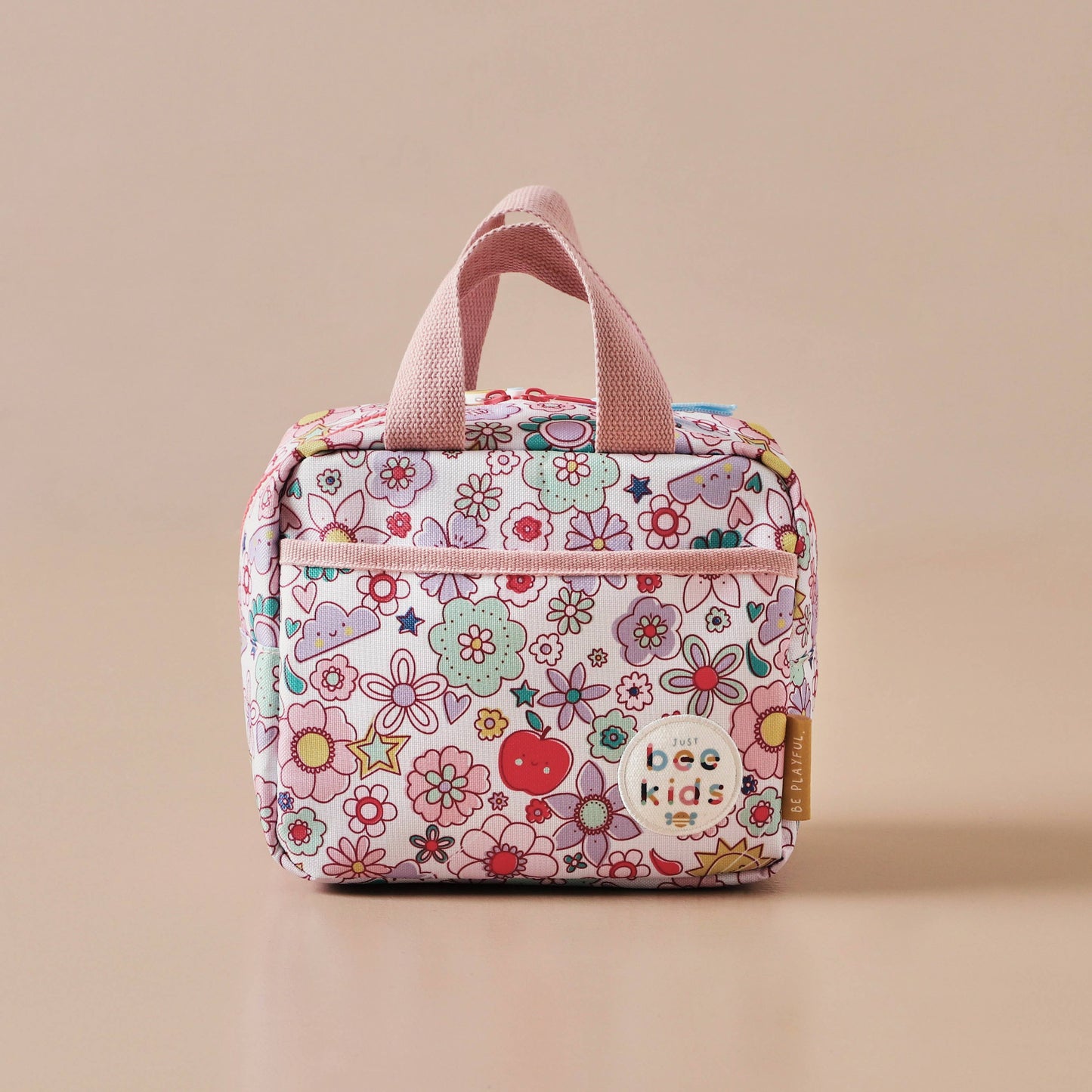 Floral-patterned lunch bag with pink handles on a beige background
