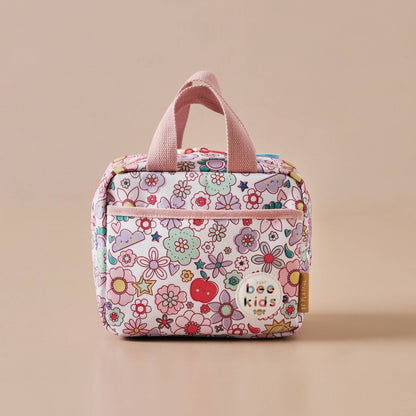 Floral-patterned lunch bag with pink handles on a beige background