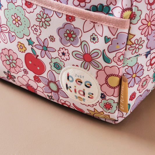 Floral-patterned pouch with 'Just Bee Kids' label on a beige background