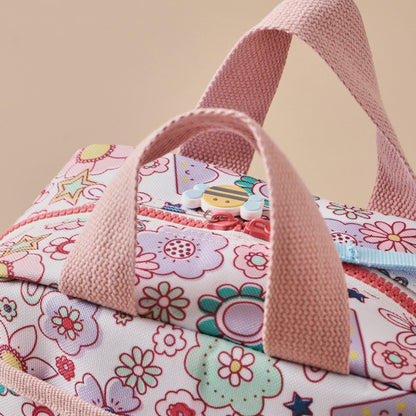 Floral-patterned bag with pink handles on a beige background
