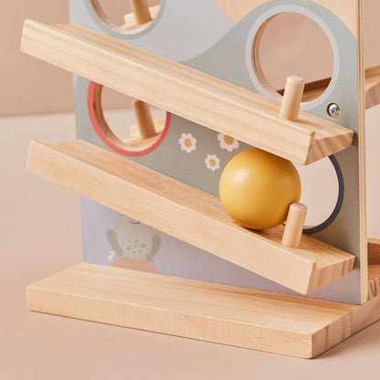 Wooden toy with a yellow ball on a ramp against a neutral background