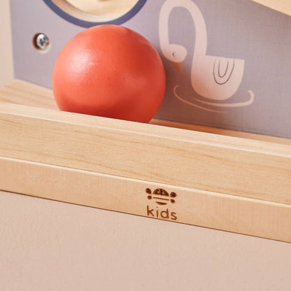 Red ball on a wooden surface with 'kids' branding in the background