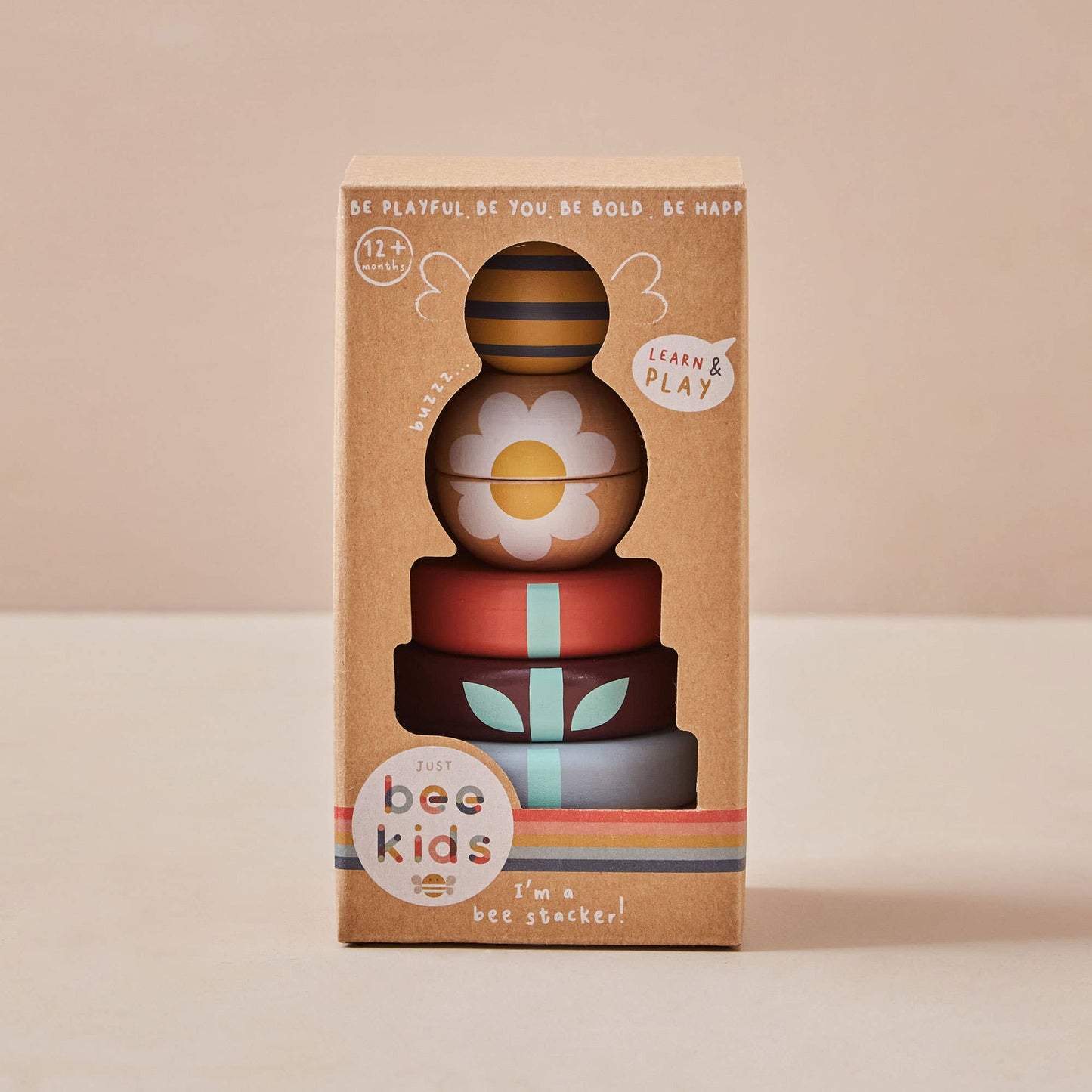 Stack of colorful wooden toys with 'bee kids' branding on a beige background