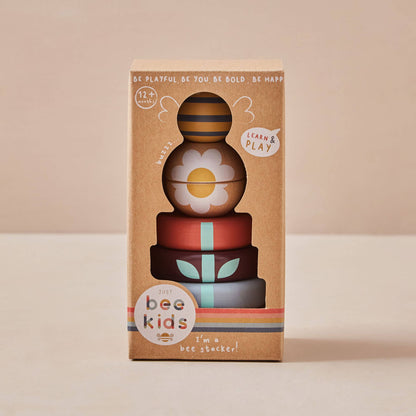 Stack of colorful wooden toys with 'bee kids' branding on a beige background