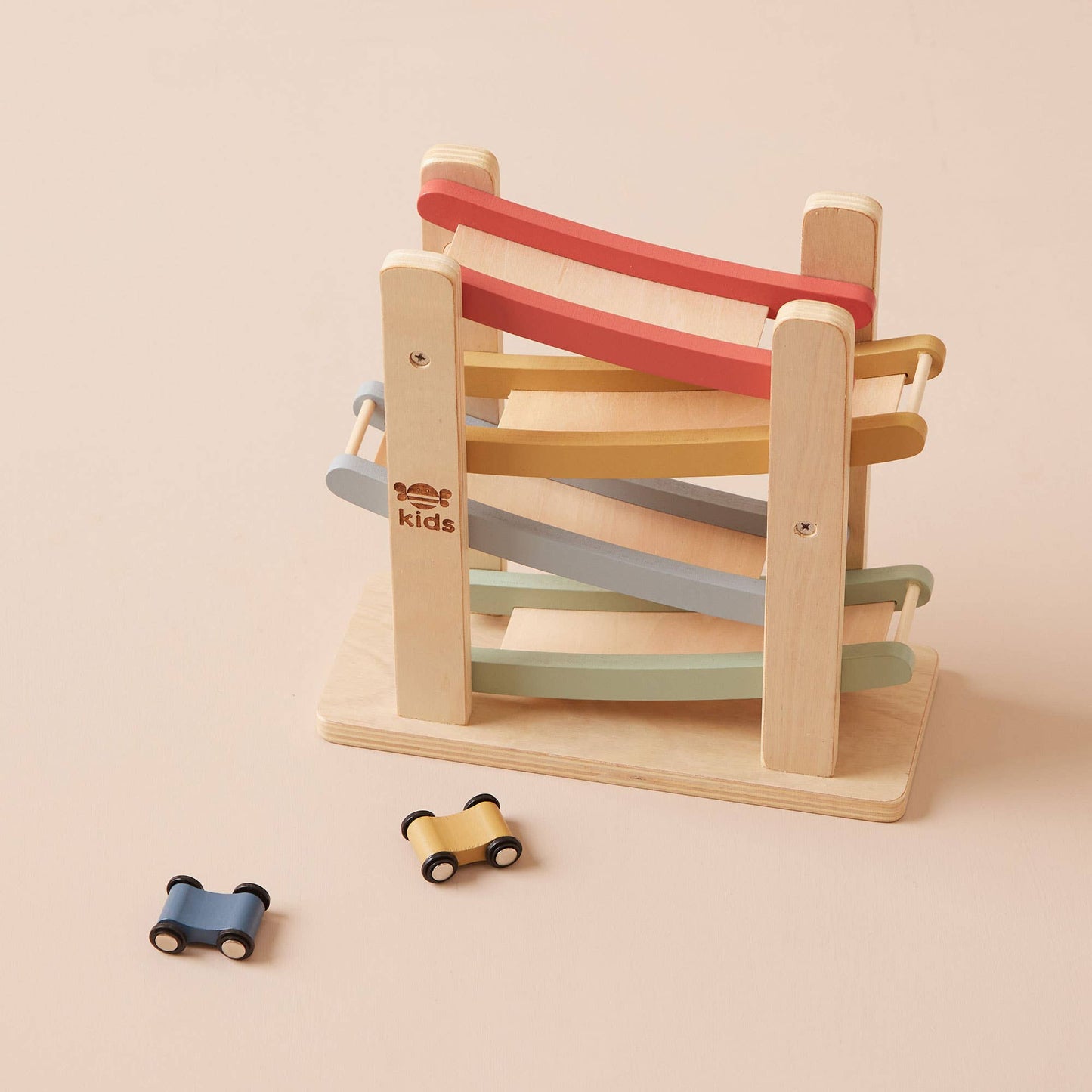 Wooden toy with colorful striped band and small cars on a beige background
