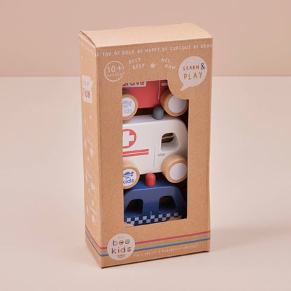 Box of wooden toy cars with visible branding on a beige background