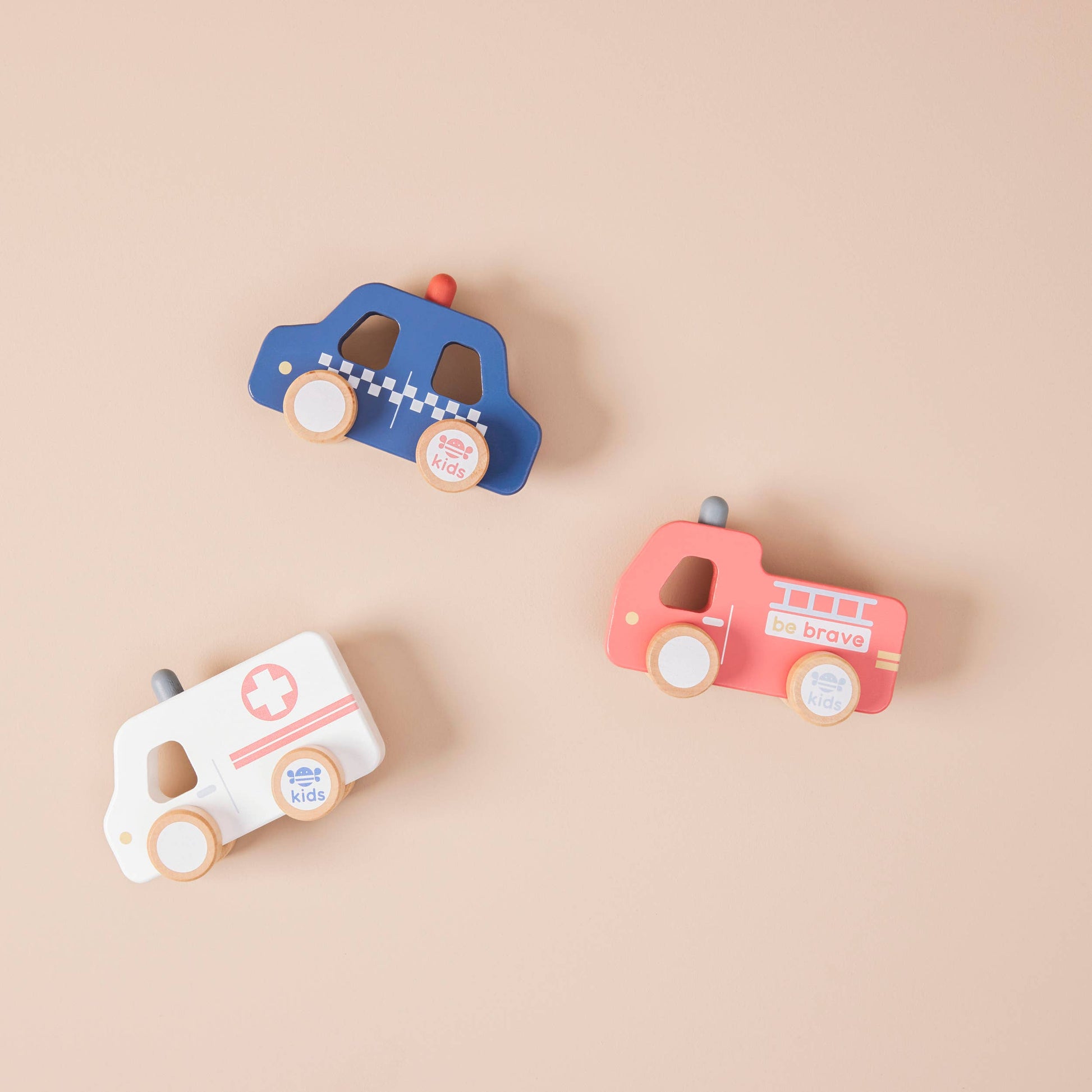 Set of three wooden toy cars on a beige background