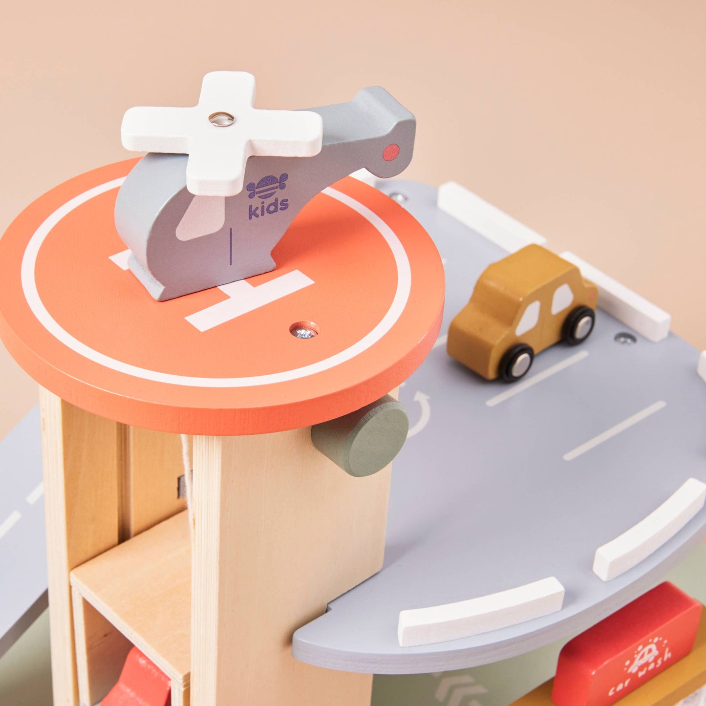 Wooden toy set with a roundabout and cars on a beige background