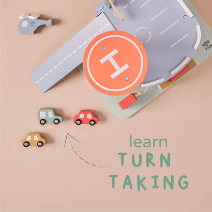 Toy road mat with cars and a helicopter on a beige background, featuring text 'learn TURN TAKING'.