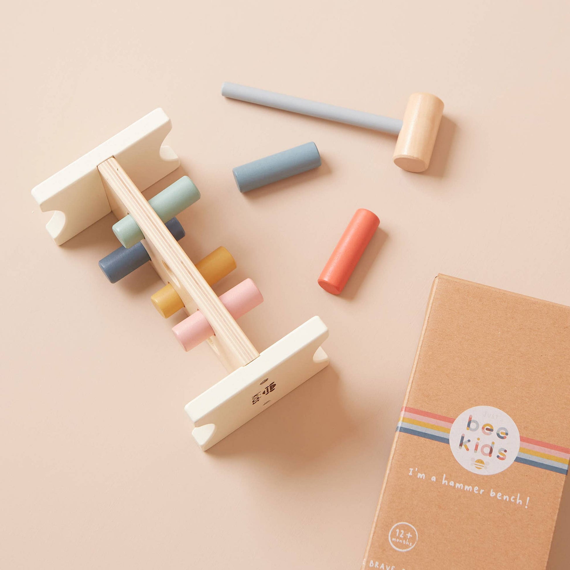 Wooden hammer and block set with colorful blocks on a beige background, featuring 'bee kids' brand.