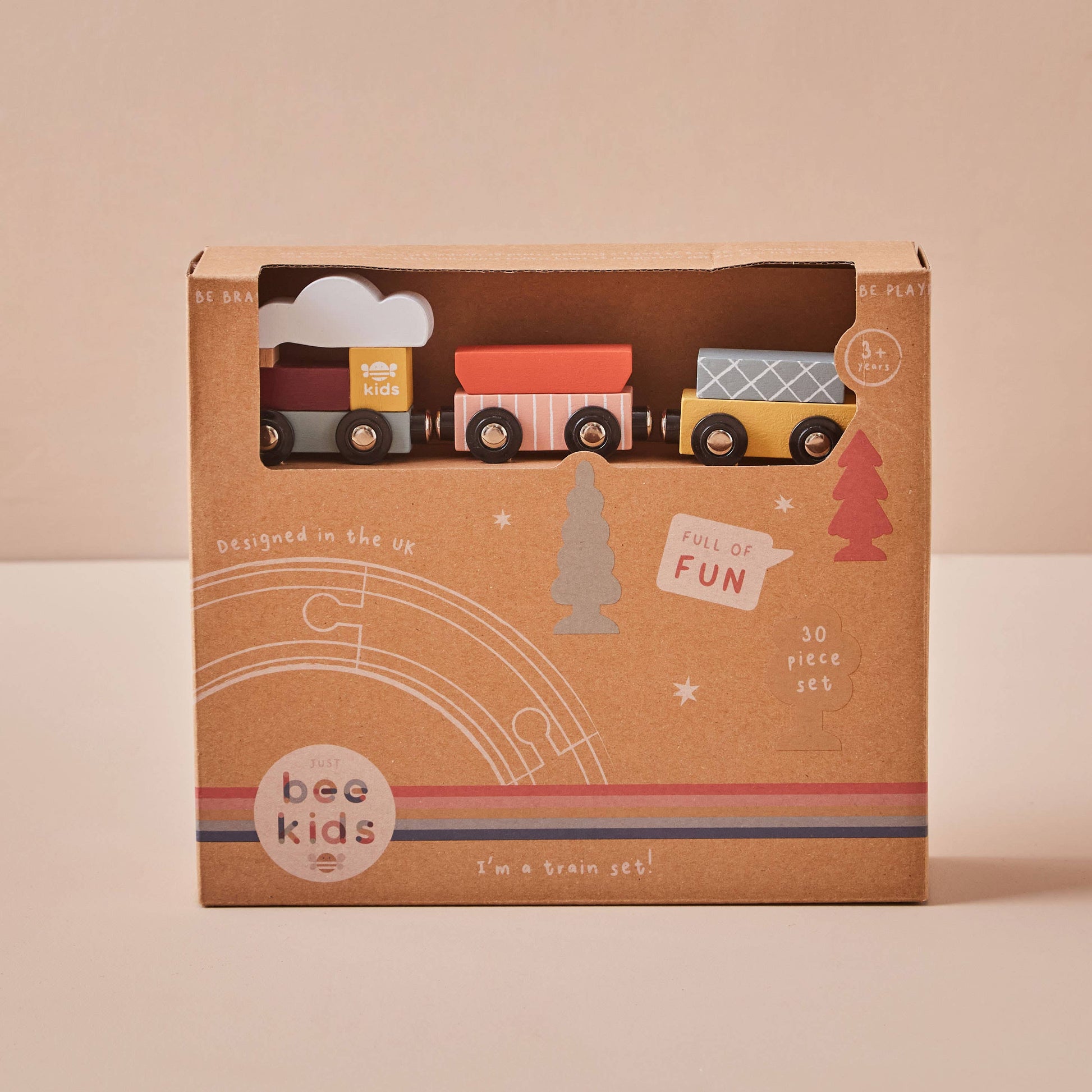 Box of toy train set with 'bee kids' branding on a beige background