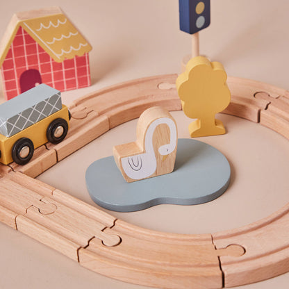 Wooden toy train set with a circular track, including a yellow car, elephant figure, and traffic light.