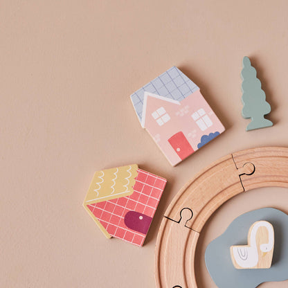 Wooden toy houses and a puzzle on a beige background