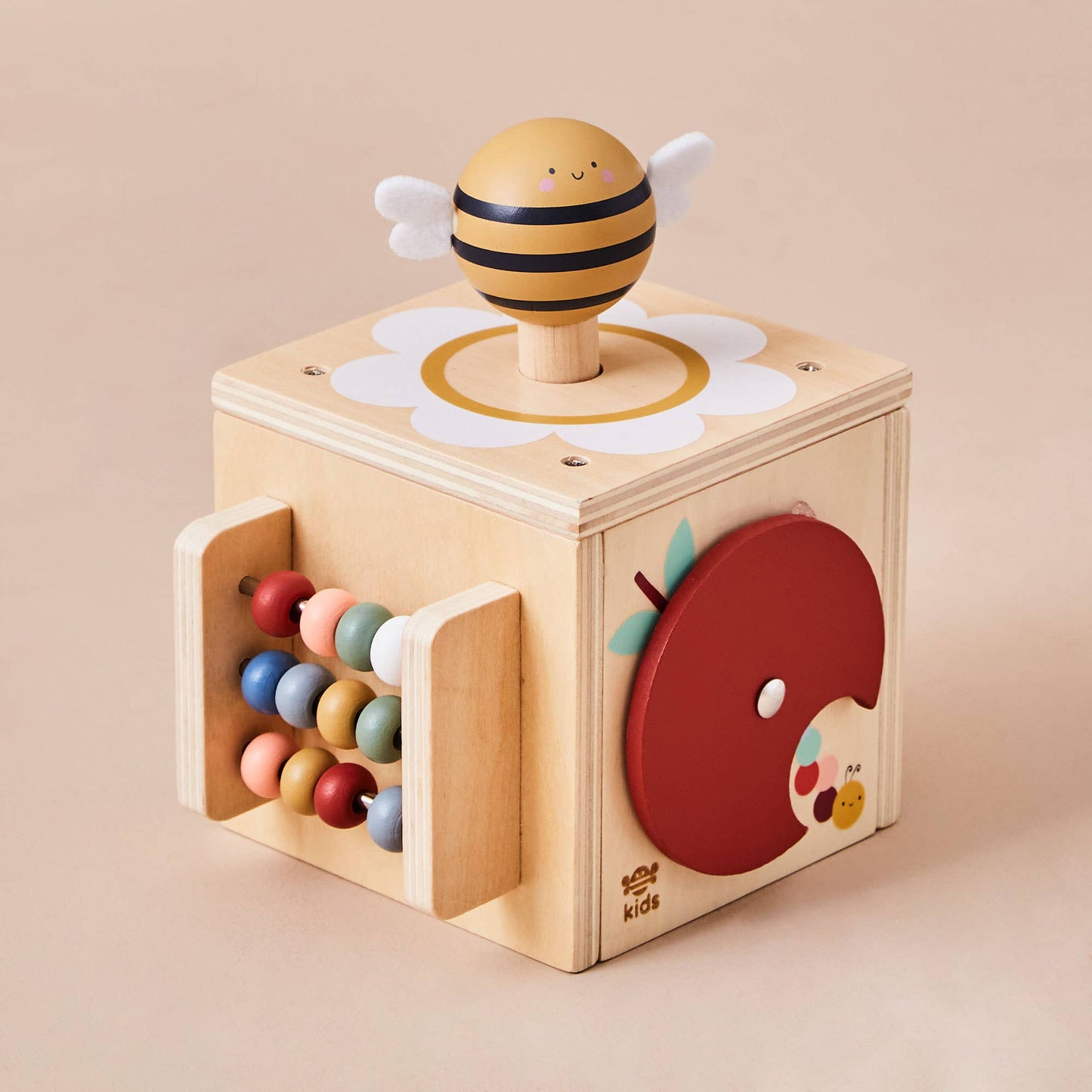 Wooden toy block with bee design and colorful beads on a beige background