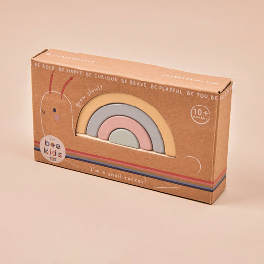 Cardboard box with rainbow design and 'bee kids' branding on a beige background