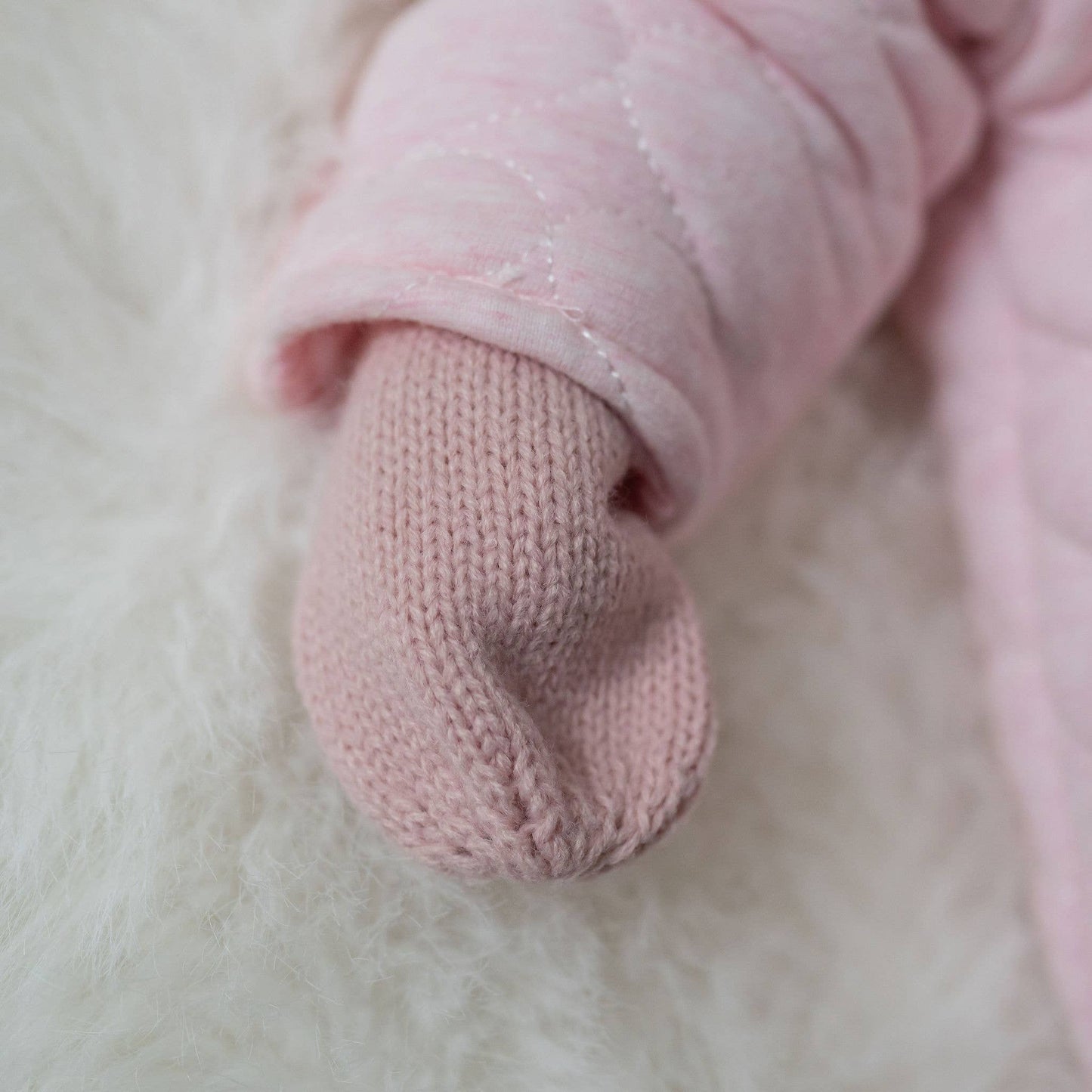 Close-up of a pink knitted sock on a soft white background