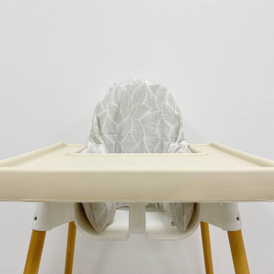 High chair with a white cushion cover on a plain background