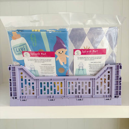Purple crate with packaged splash mats on a white background