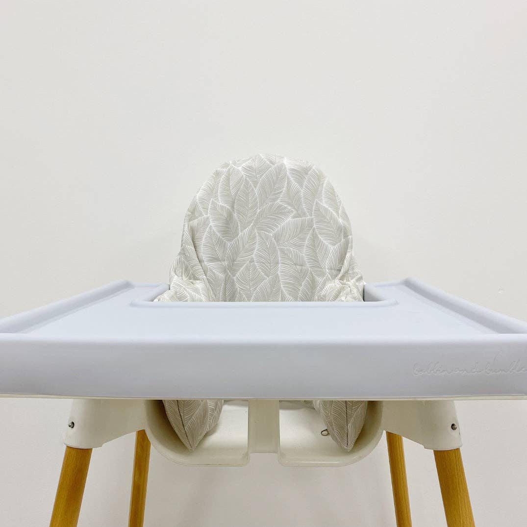 High chair with a white leaf cushion cover on a plain background