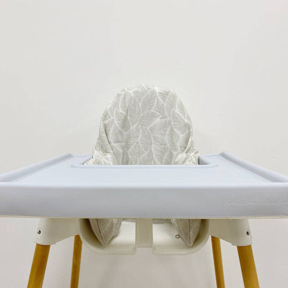 High chair with a white leaf cushion cover on a plain background