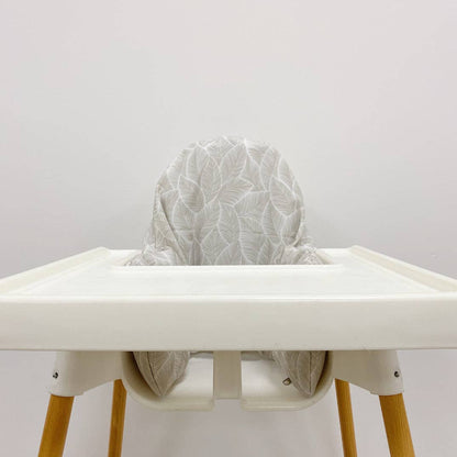 White high chair with a textured grey cushion on a plain background