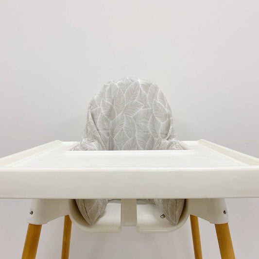 White high chair with a textured grey cushion on a plain background