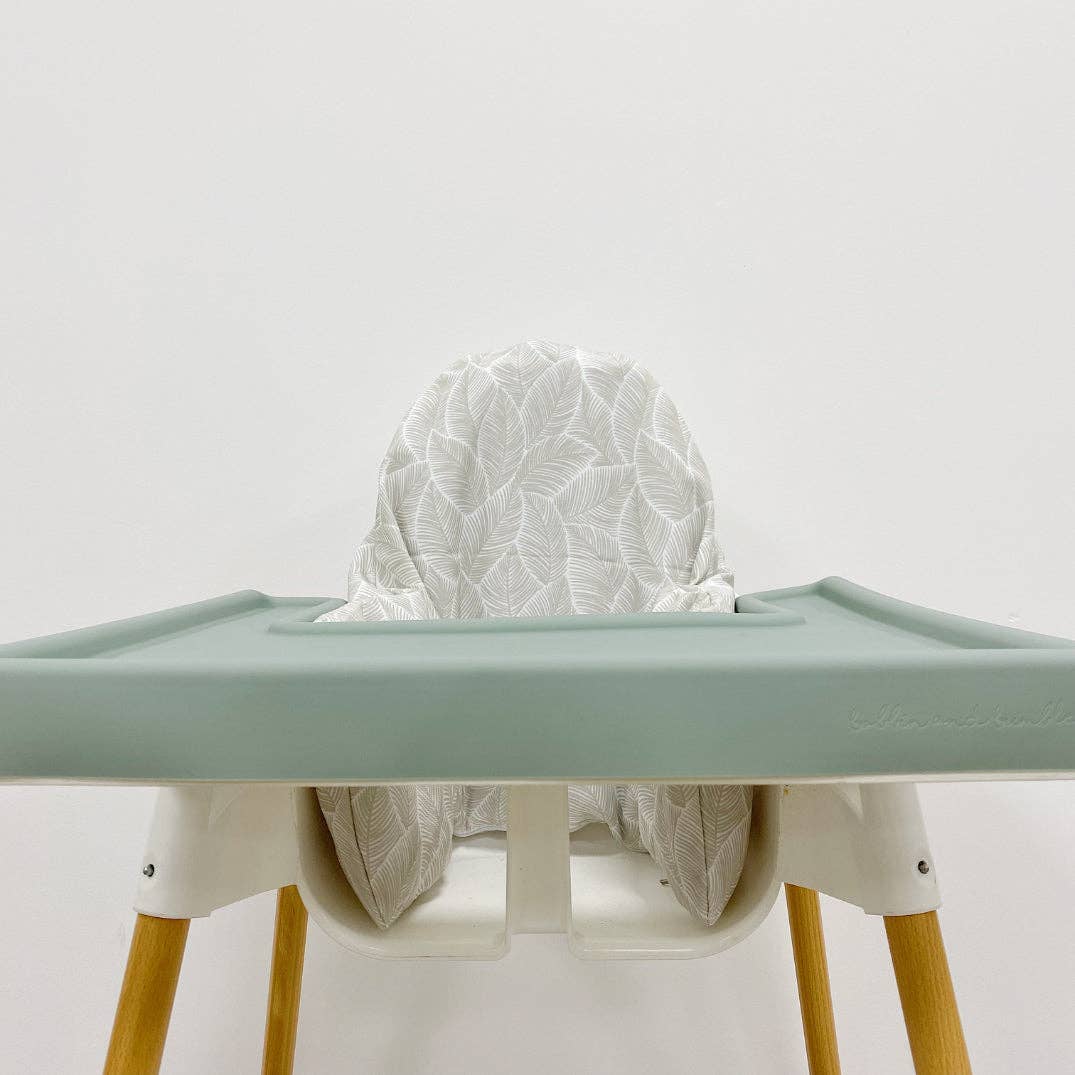 High chair with a light green silicone tray cover and wooden legs on a white background