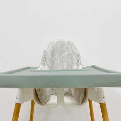 High chair with a light green silicone tray cover and wooden legs on a white background