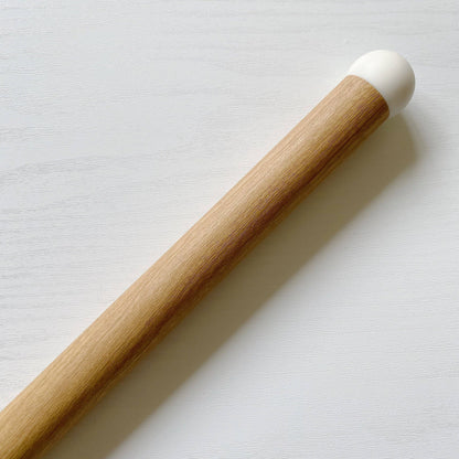 Wood effect chair leg cover with a white end on a light grey background