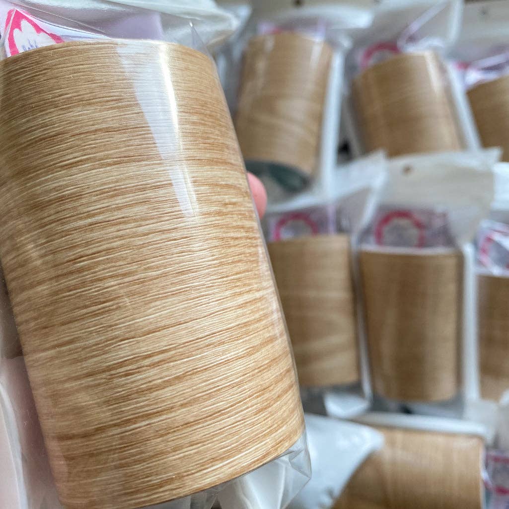 Close-up of a wood effect vinyl leg wrap with more in the background.