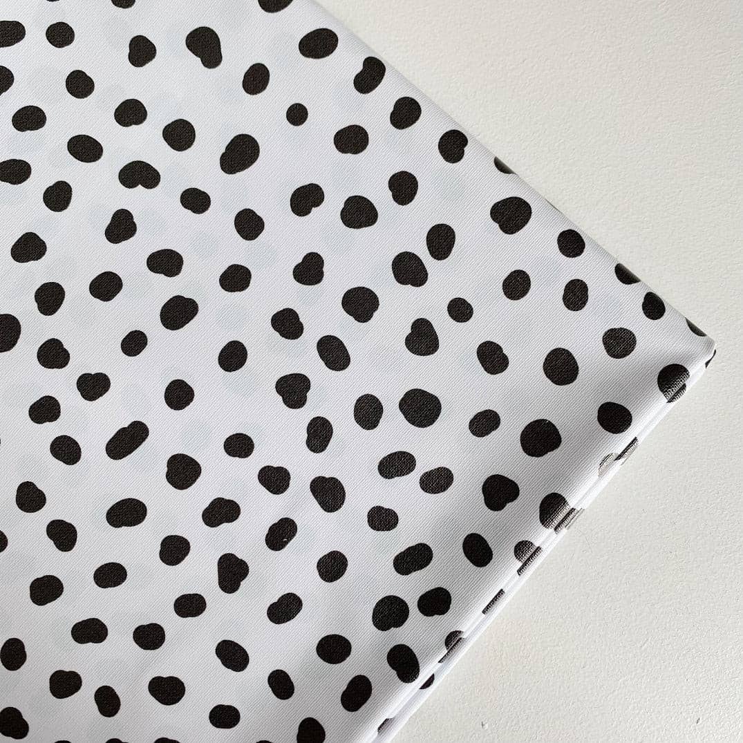 Splash mat with black polka dots on a white background