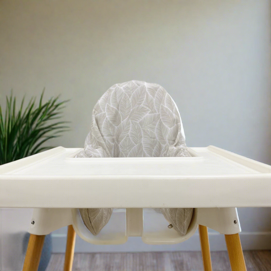 White high chair with a textured white cushion against a neutral background