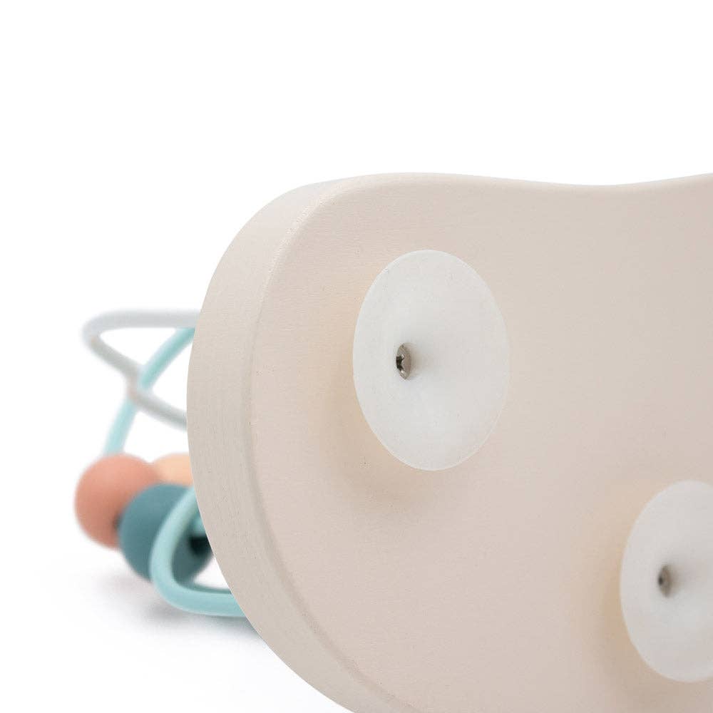 Close-up of a baby rattle with beige base and colourful beads on a white background