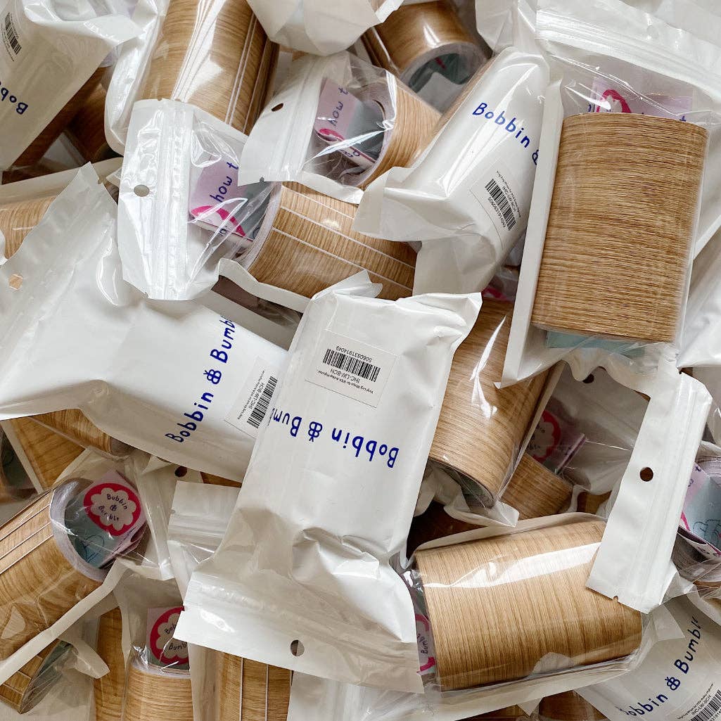 Pile of Bobbin & Bum packaging with wood effect highchair leg wraps inside