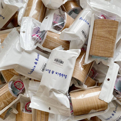 Pile of Bobbin & Bum packaging with wood effect highchair leg wraps inside