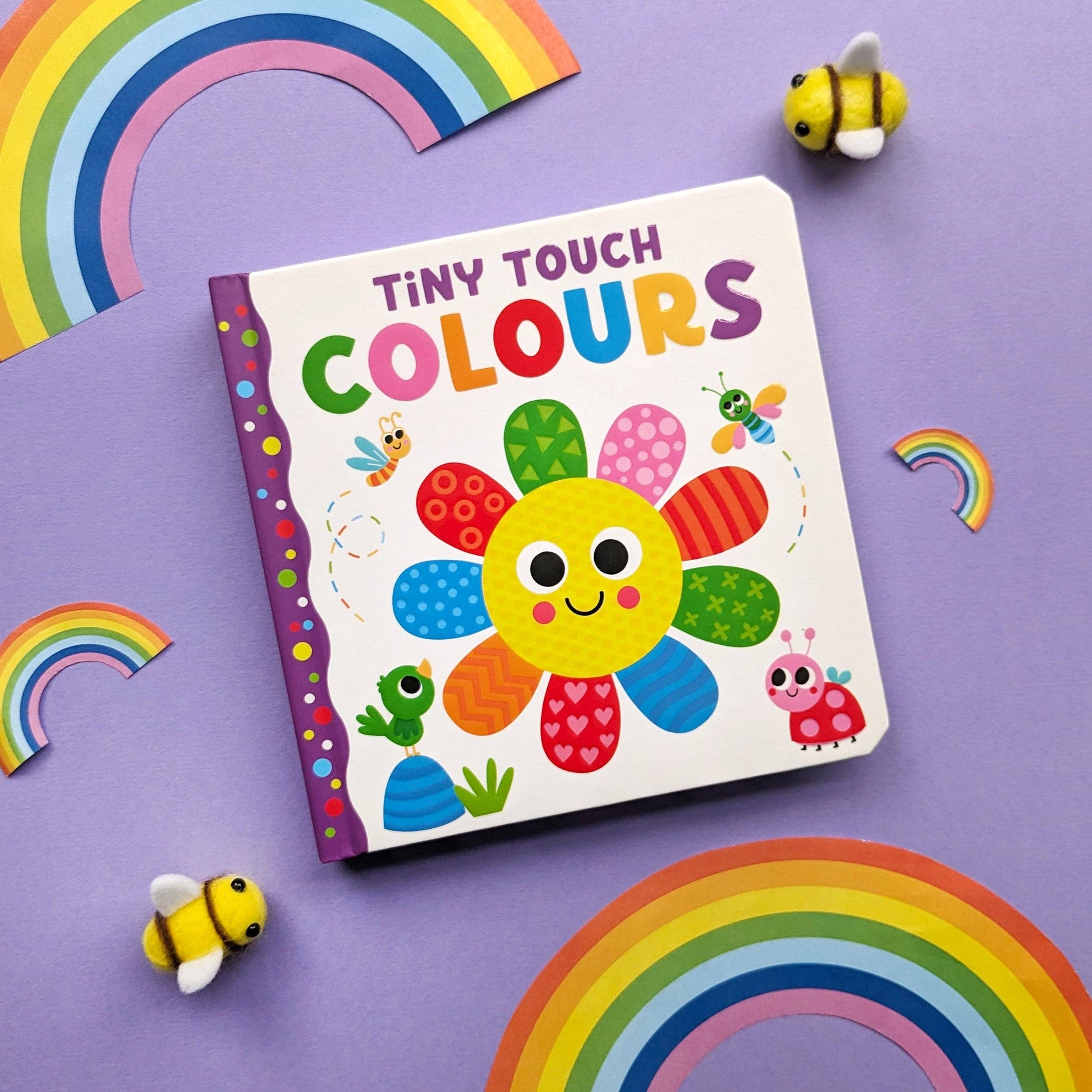 Children's book titled 'Tiny Touch Colours' with colorful illustrations on a purple background with rainbows and bees.